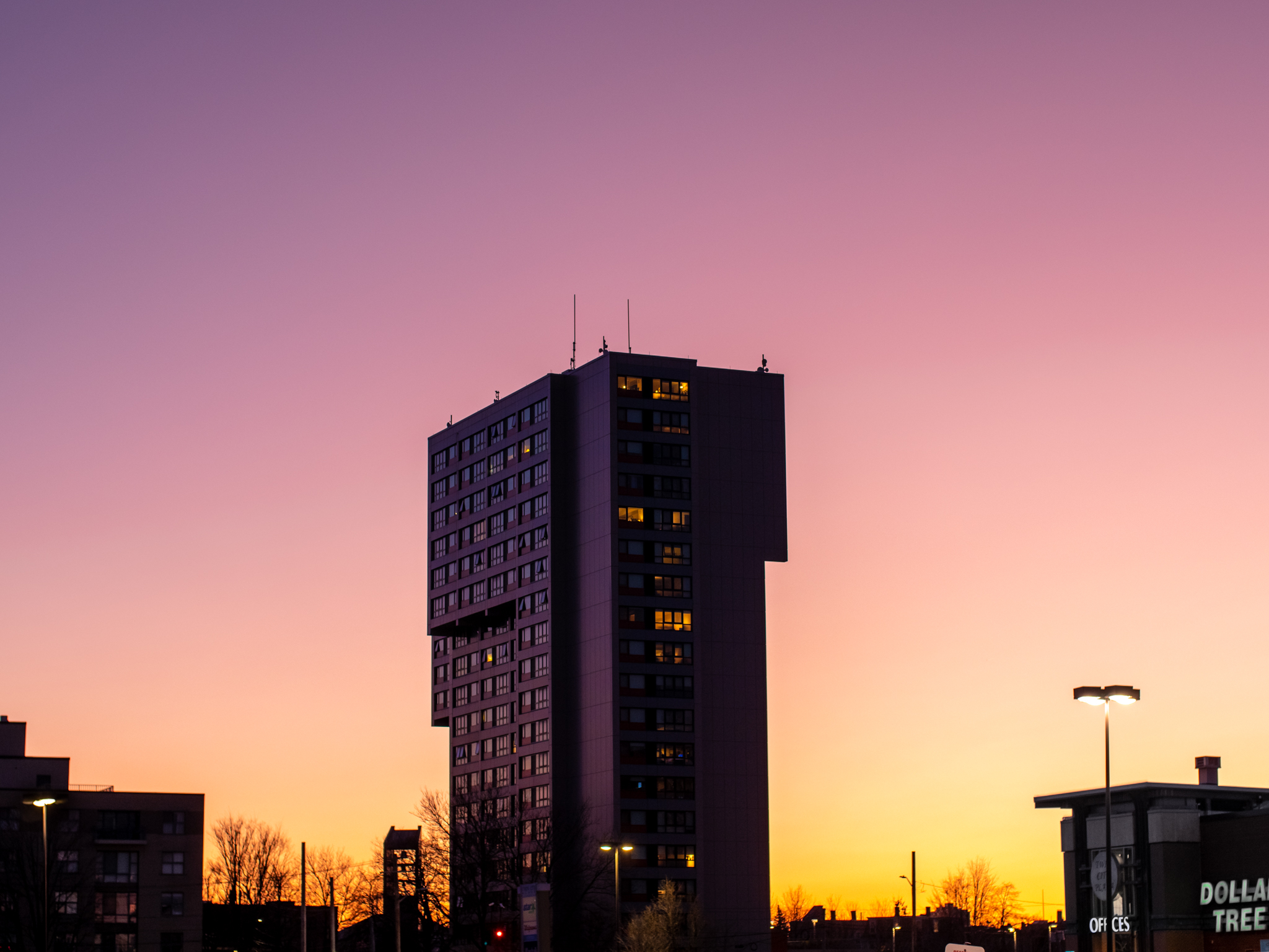 A pink and yellow image of a building and sunset.